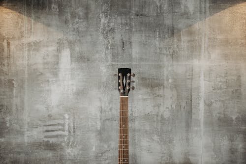 Brown Acoustic Guitar on Gray Wall