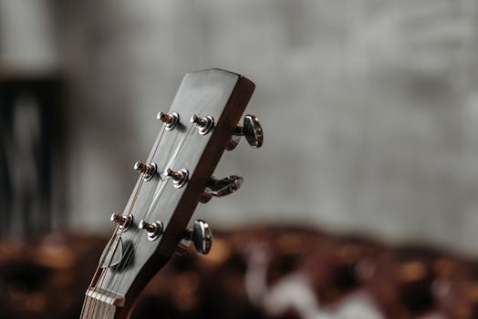 Detailed image of an acoustic guitar headstock with tuning pegs in focus.