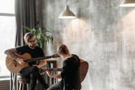 Man in Black Long Sleeve Shirt Playing Guitar