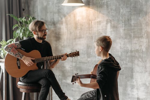 Free Teacher and His Student Playing Acoustic Guitar Stock Photo