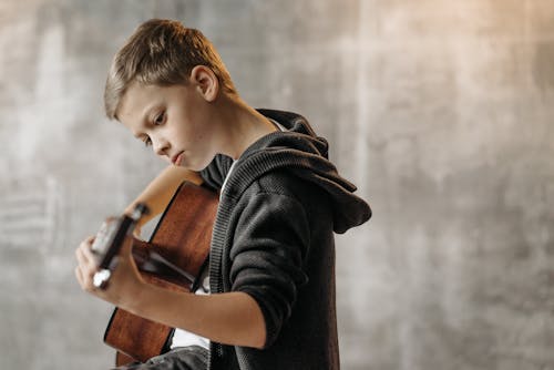 Free Close-Up Shot of a Boy Playing Acoustic Guitar Stock Photo