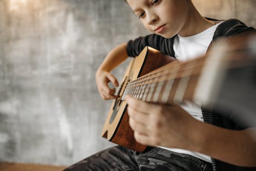 Free Close-Up Shot of a Boy Playing Acoustic Guitar Stock Photo