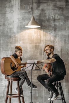 Teacher and young boy in guitar lesson, under modern lighting, indoors.