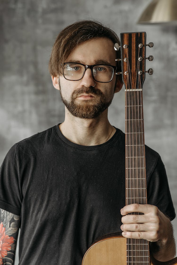 A Man Holding An Acoustic Guitar