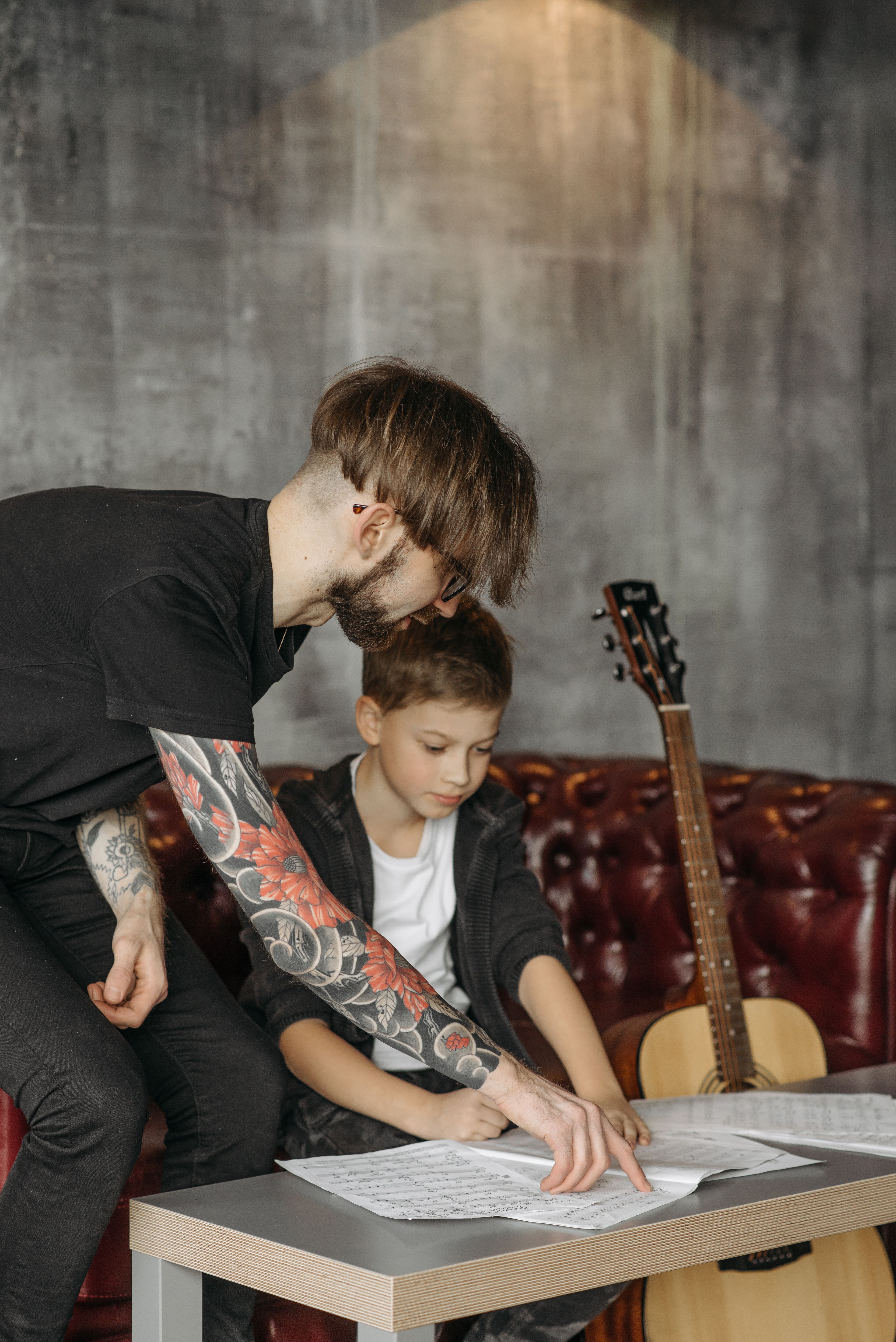 A guitar teacher going through a chart with a student