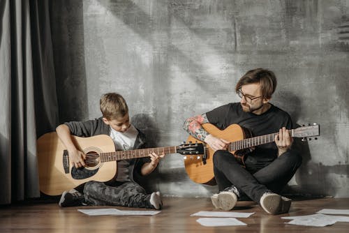 Man and Child Playing Guitars