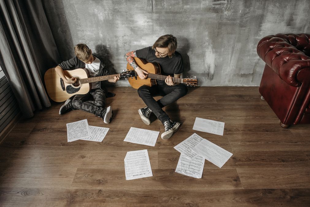 Duas pessoas praticando violão juntas, exemplo de aprender uma habilidade nova com prática constante