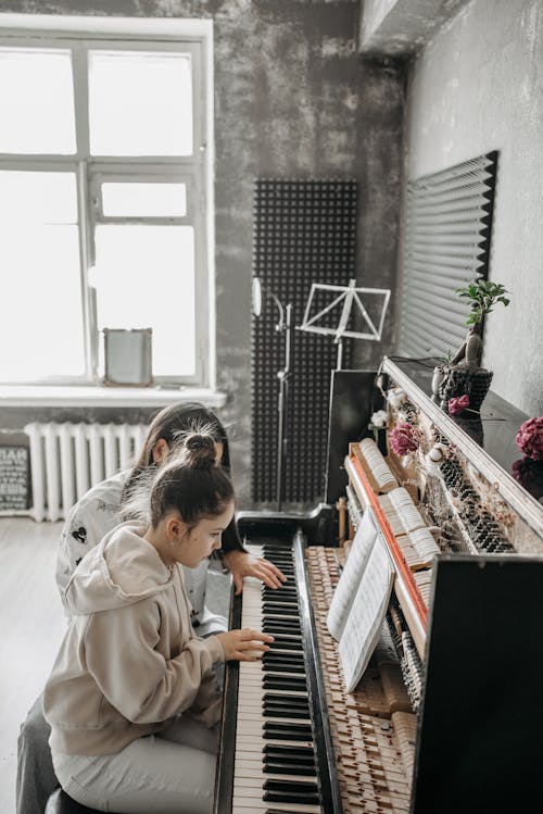 A Girl in Beige Jacket Playing Piano