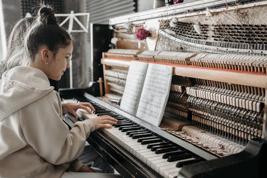 A young woman intently playing an upright piano in a cozy music studio.