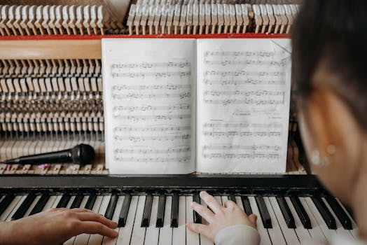 Pianist playing piano while reading sheet music, highlighting musical focus.