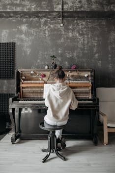 A young girl plays piano in a stylish, urban music studio, showcasing her musical dedication.