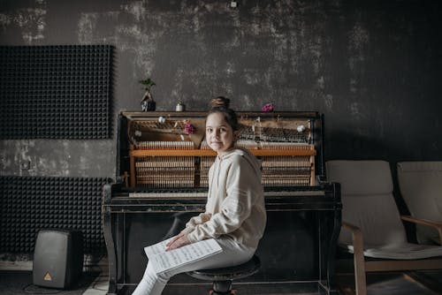 Woman in Beige Long Sleeve Hoodie Sitting on Black Wooden Stool