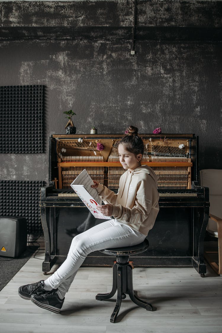 Girl Wearing Hoodie Sweater Reading A Music Sheet