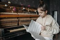 Woman in White Long Sleeve Shirt Playing Piano