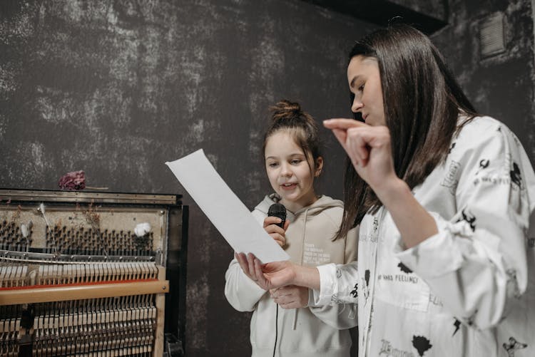 A Teacher Teaching A Student How To Sing