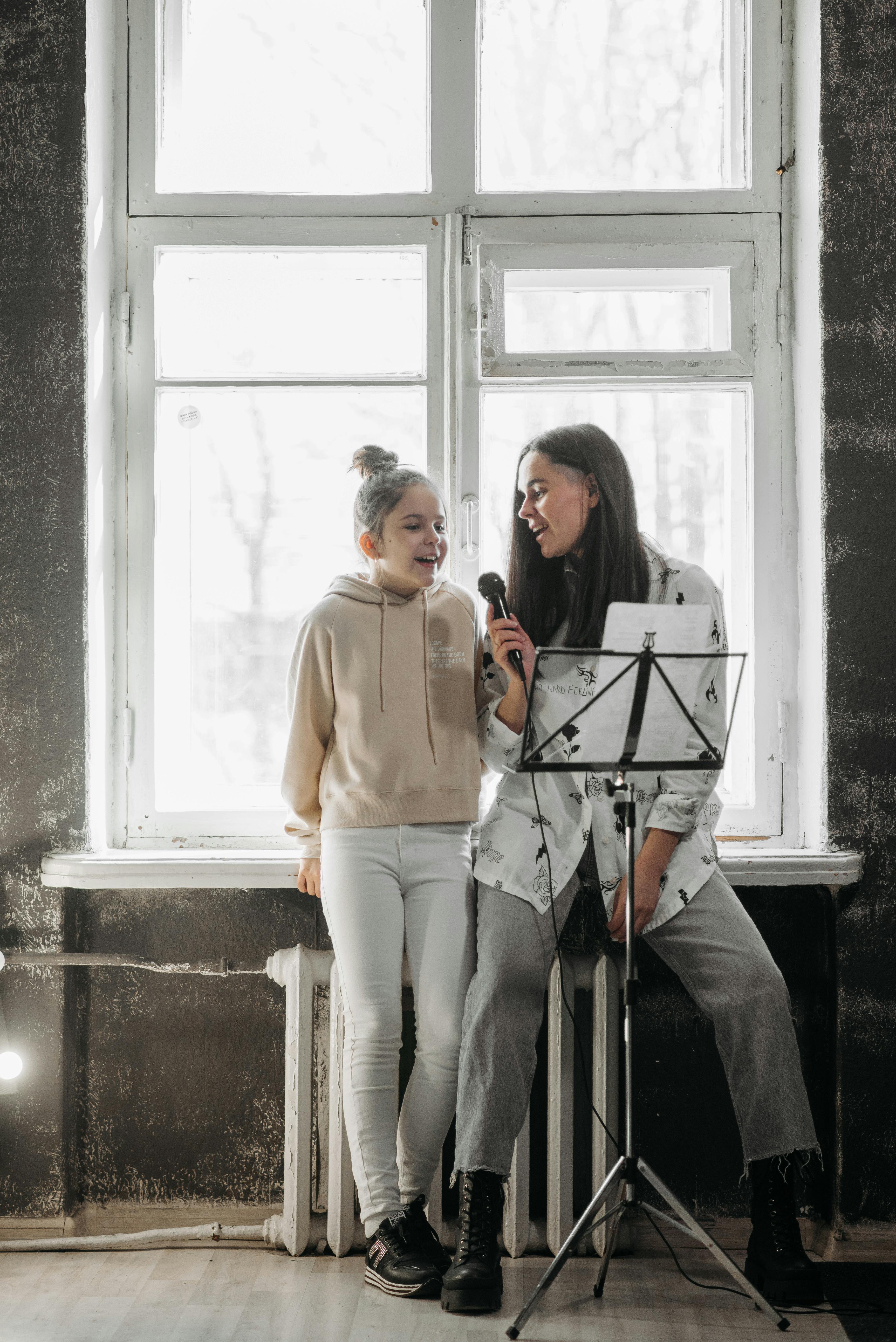 a woman teaching a girl how to sing