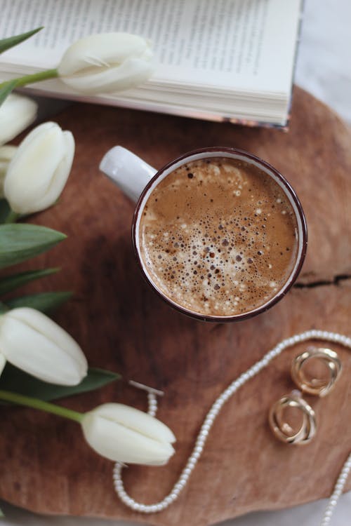 Free Mug of cacao with classy accessories and tulips bouquet placed on tray near book Stock Photo