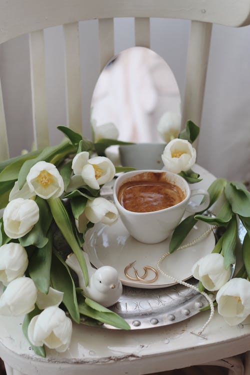 Free Fresh flower and cup of cacao served on tray on chair Stock Photo