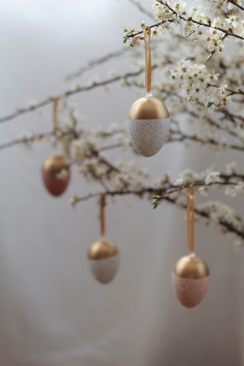 Free Creative egg shaped baubles hanging on blooming branches of cherry tree during Easter celebration Stock Photo