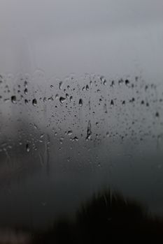 Raindrops on a window create a moody atmosphere, perfect for rainy day themes.