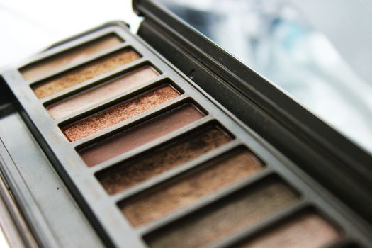 Close-up of a neutral-tone eyeshadow palette showcasing various shades.. close, neutral, tone