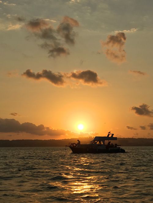 Free A tranquil scene of a silhouetted boat against a warm İstanbul sunset on the sea. Stock Photo