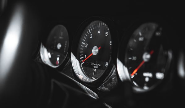 Dynamic close-up of car dashboard gauges with focus on speedometer and RPM dial, capturing precision.
