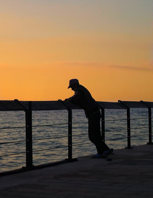 Unrecognizable man on embankment in twilight