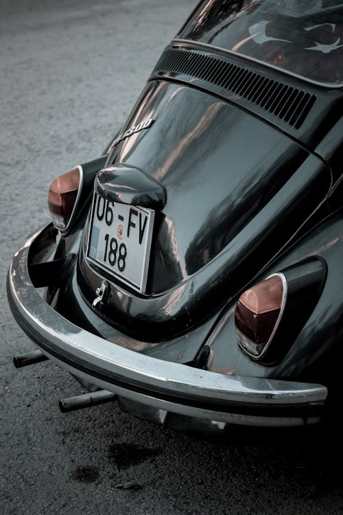 Free Back part of old fashioned black car with number plate on asphalt in daytime Stock Photo