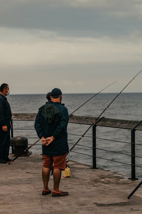 Unrecognizable man standing near fishing rods