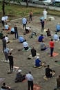 Muslim men sitting on paved street and praying