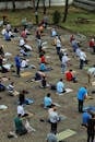 Muslim men sitting on rugs on paved ground while giving prayers to god all together on summer day