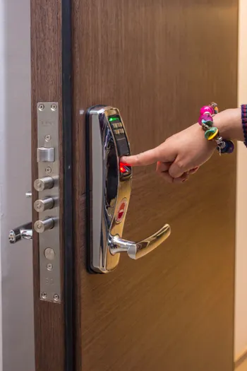 Digicode d'une serrure connectée installée sur une porte d'entrée en bois