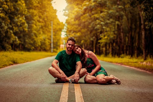 A Couple Sitting on the Road Together