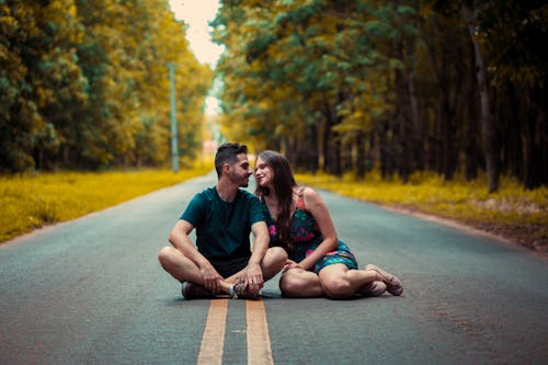 A Couple Sitting in the Middle of the Road