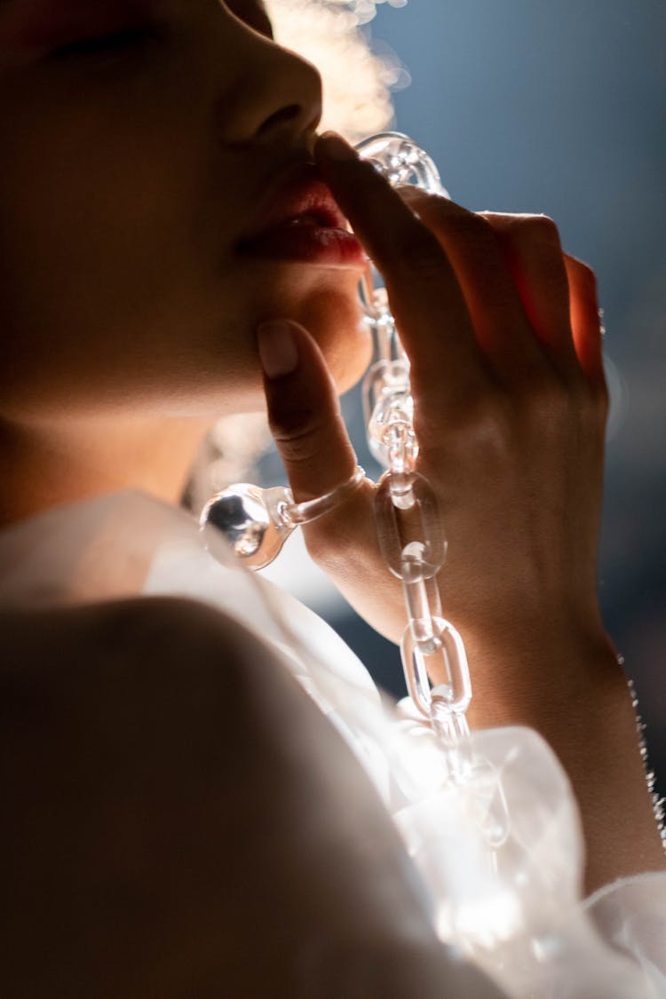 Woman In Close Up Photography Holding A Glass Chain