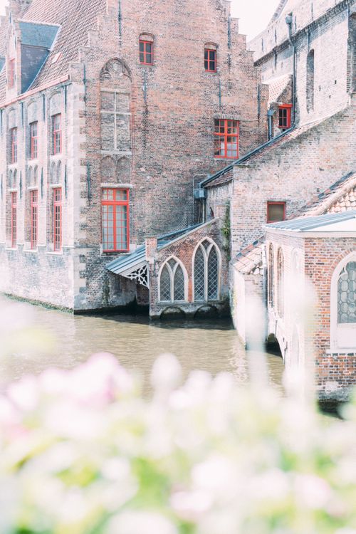 Free Charming medieval brick architecture alongside a serene canal in Bruges, Belgium. Stock Photo