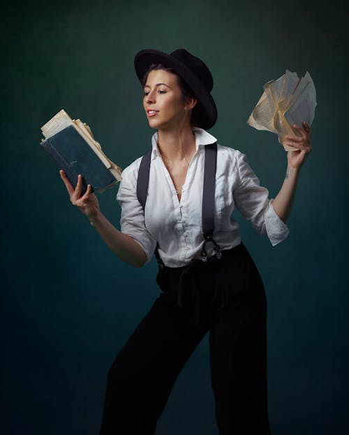 Photo of Person Holding a Book and Papers