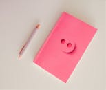 Pink Notebook on White Surface