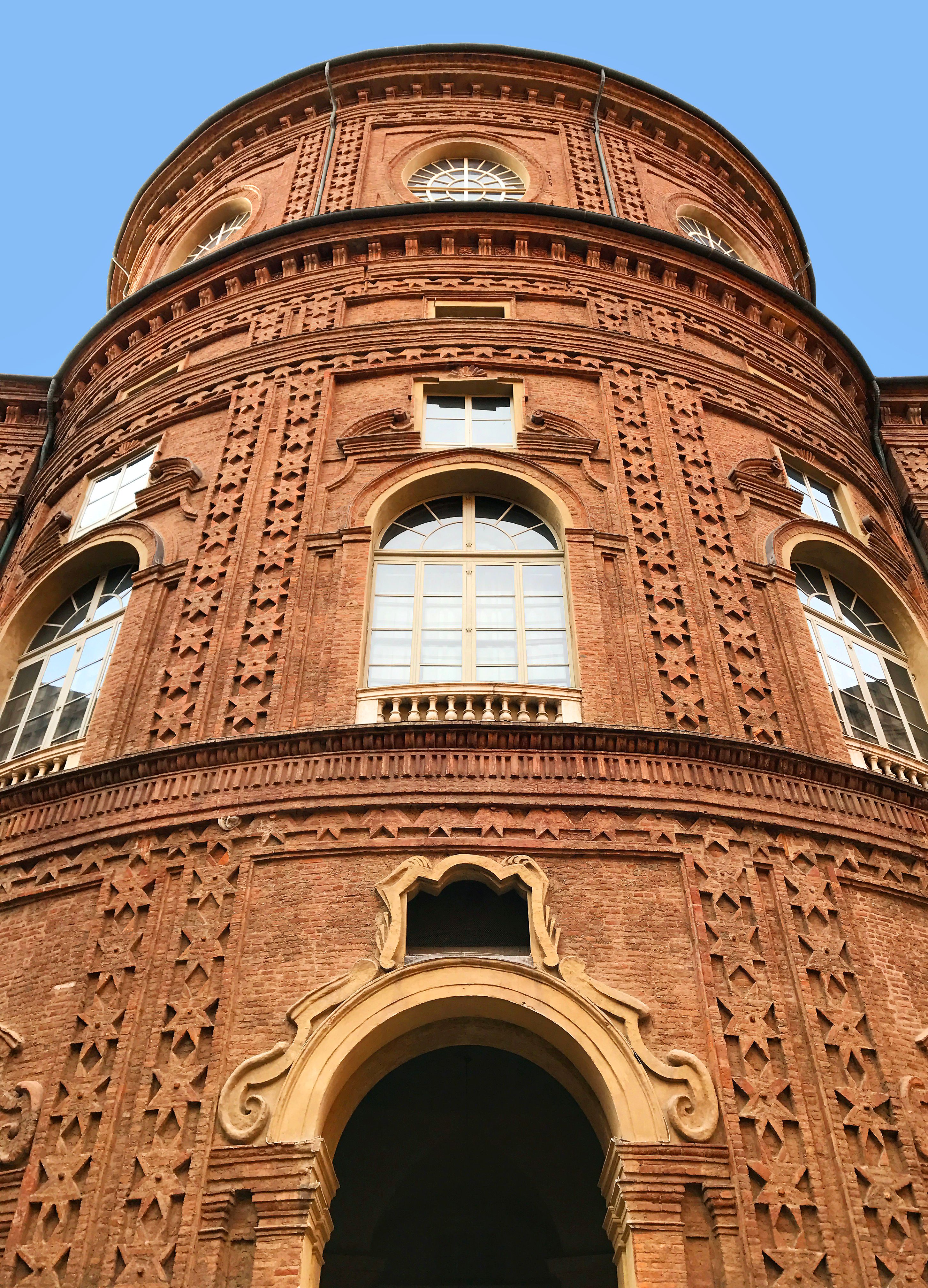 Low-angle shot of Palazzo Carignano, showcasing its baroque architecture and ornate windows in Turin, Italy.