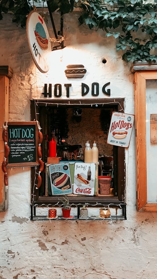 Signboard of takeaway street cafe selling hot dogs with various sauces and drinks