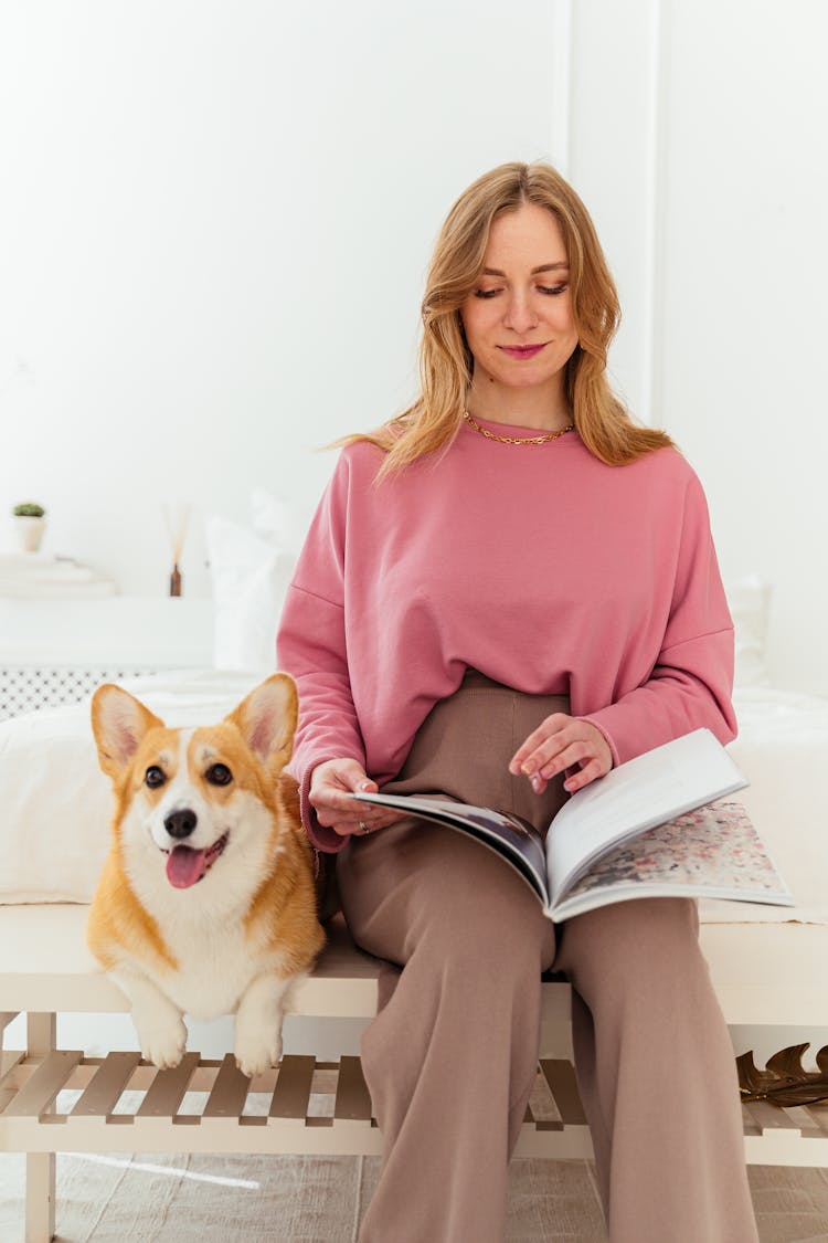 A Woman Reading A Magazine Beside Her Pet Dog