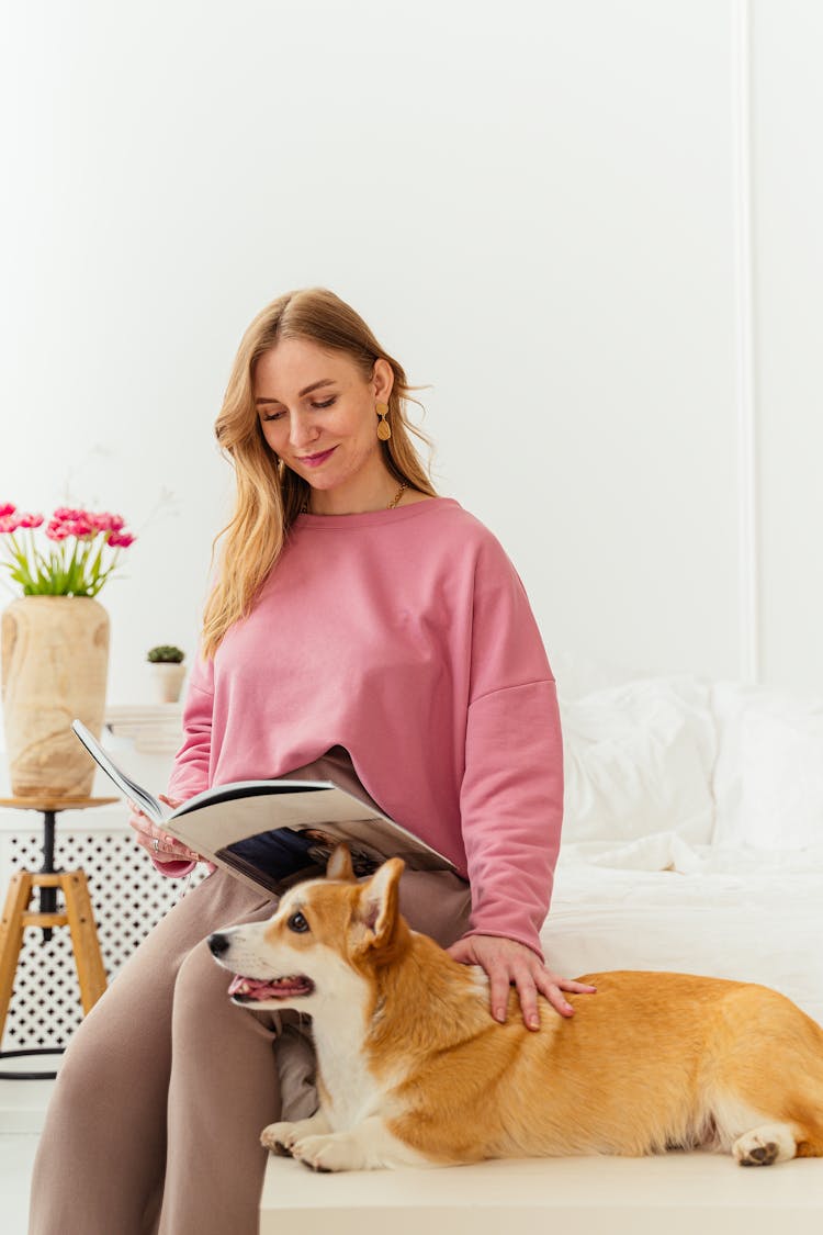 Woman Reading Magazine While Touching A Dog