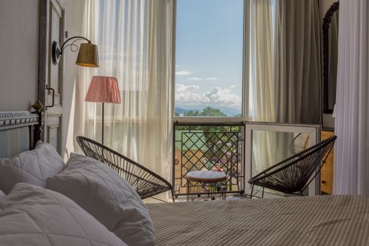 Bright and elegant bedroom featuring a cozy setup with a balcony view.