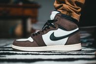 Crop leg of person wearing trendy sneakers made of white leather and brown suede and black shoelace and brand logotype
