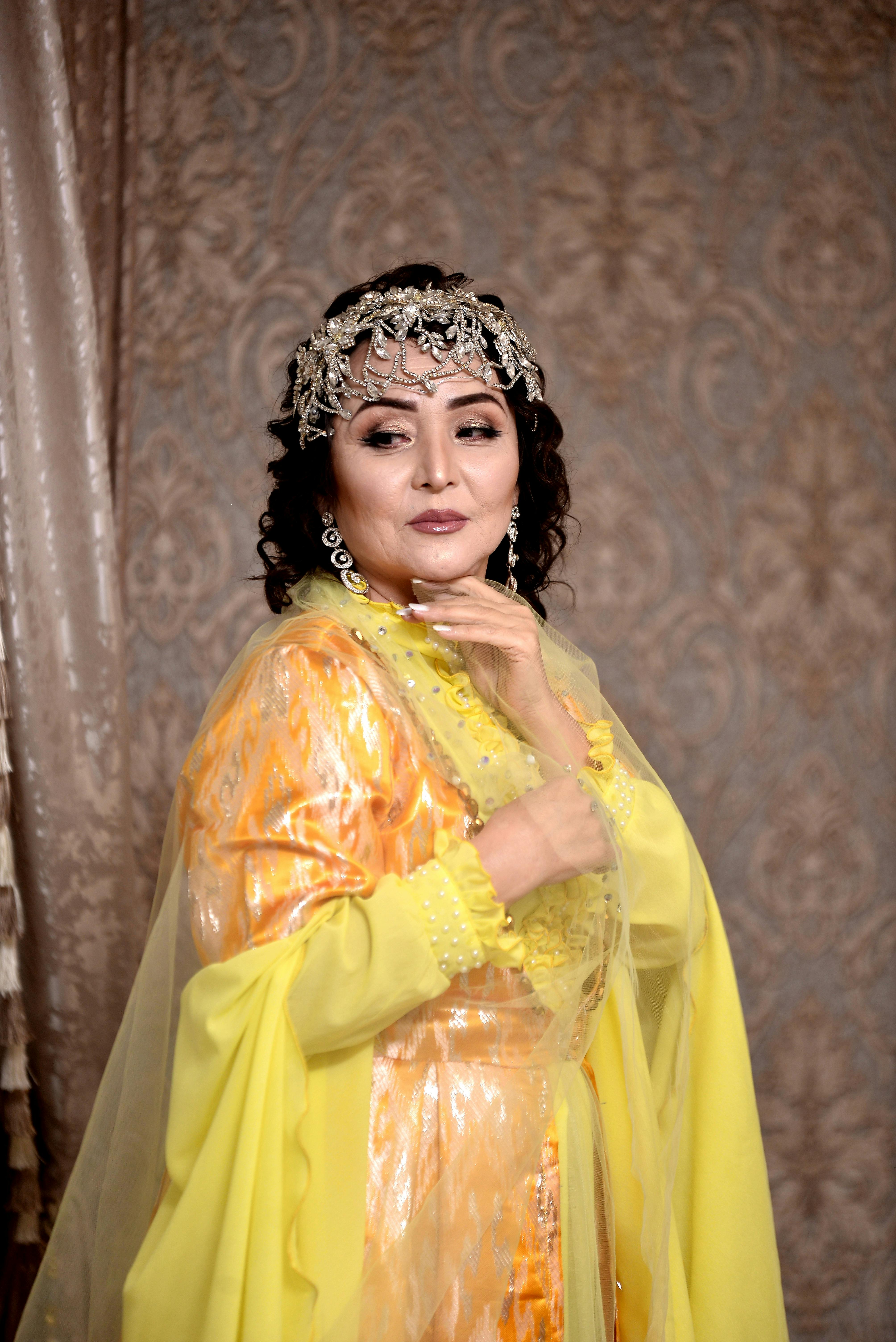 Portrait of an elegant woman in vibrant yellow traditional clothing, exuding grace.