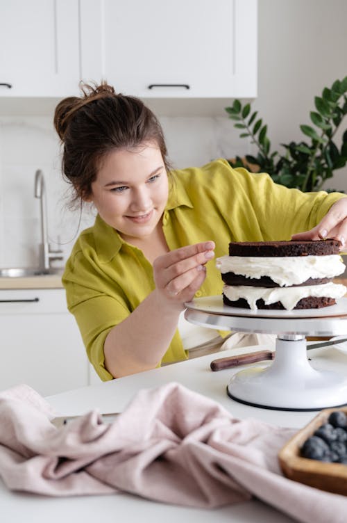 Smiling woman cooking cake in kitchen