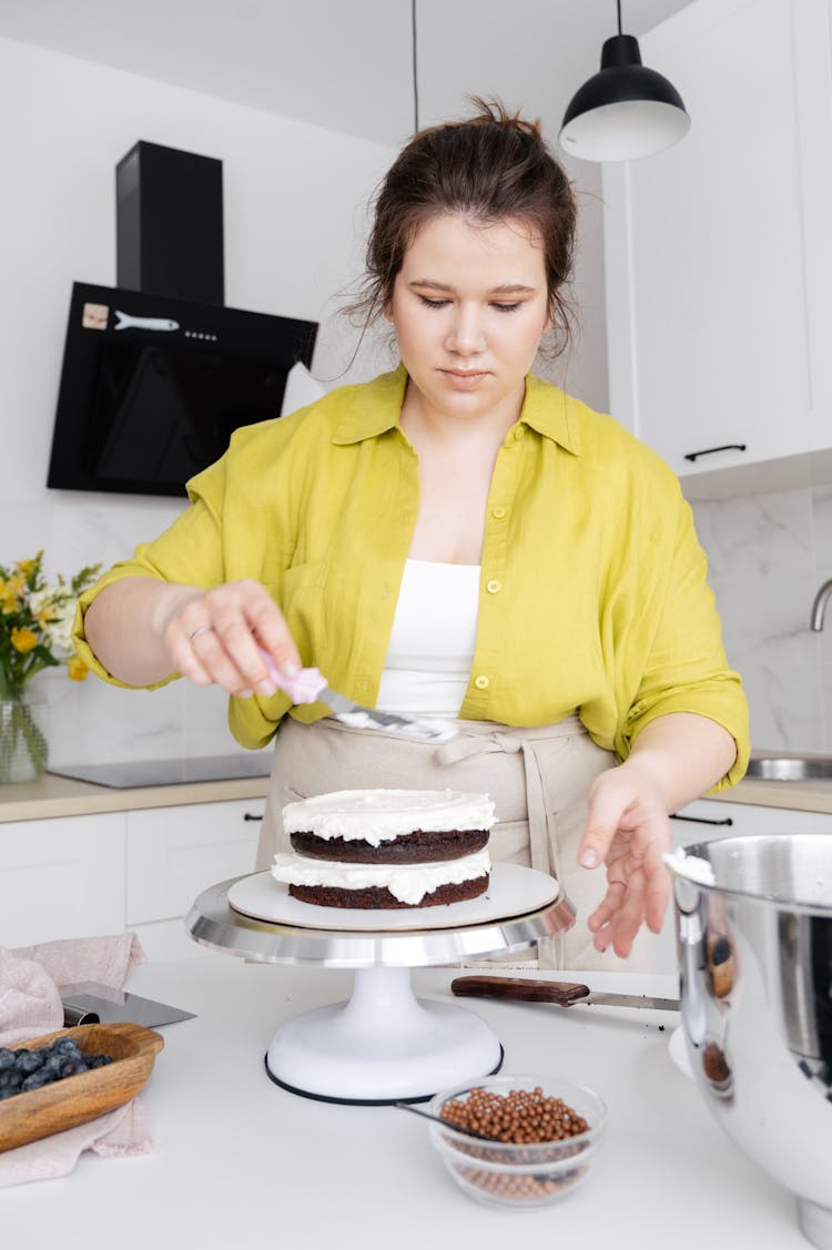 Young Woman Cooking Cake With Cream