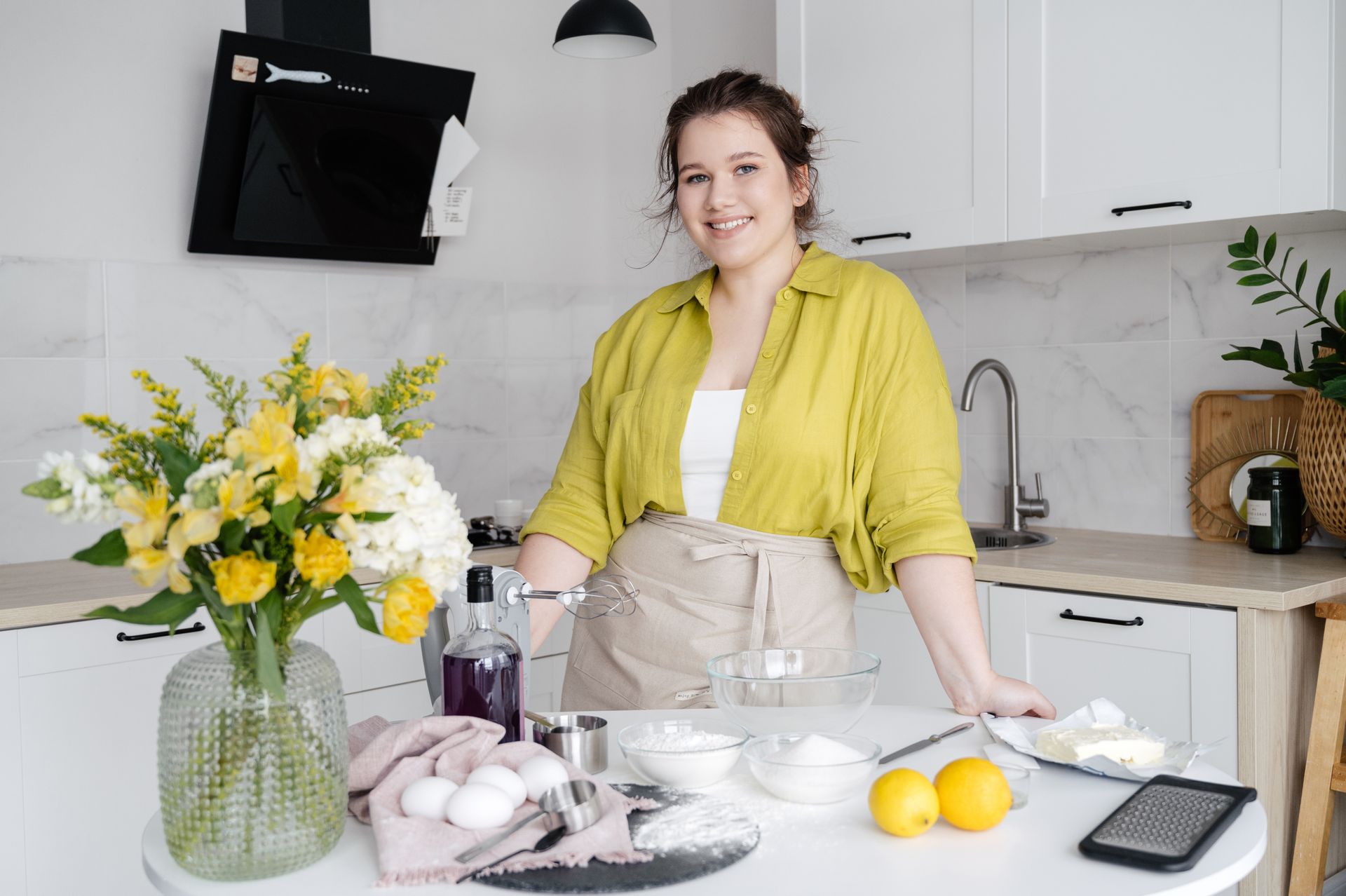 Smiling housewife with ingredients on table