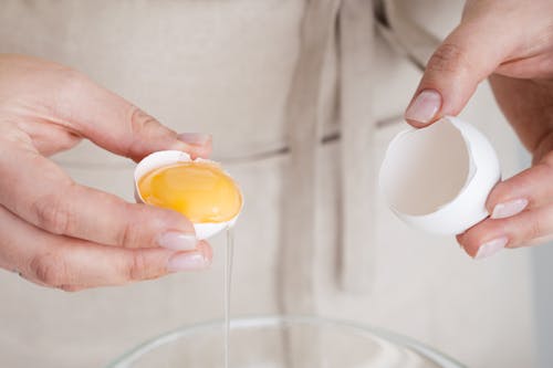 Close-Up Shot of a Person Holding a Cracked Egg